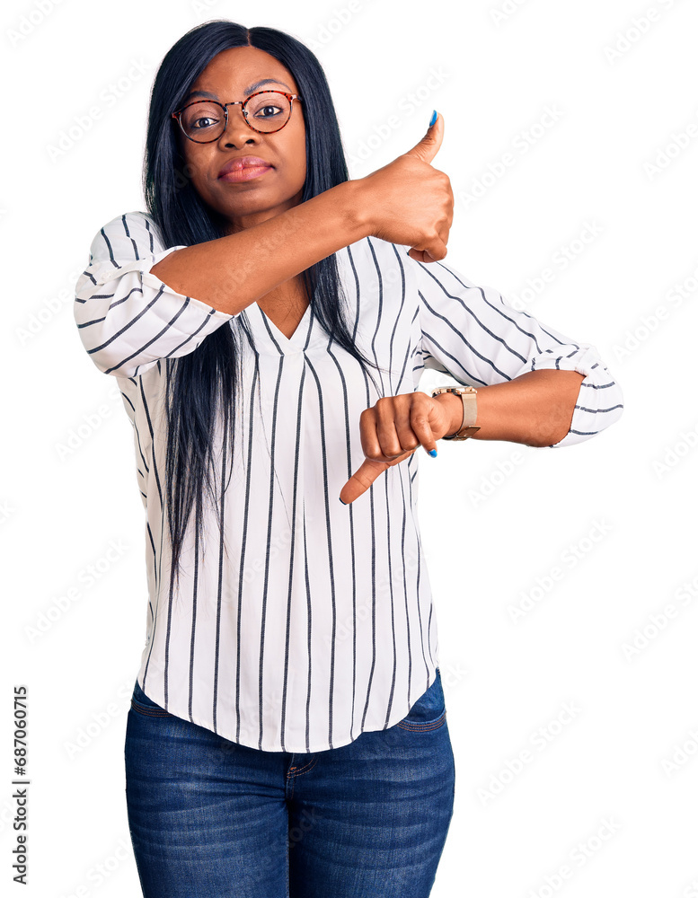 Canvas Prints Young african american woman wearing casual clothes and glasses doing thumbs up and down, disagreement and agreement expression. crazy conflict