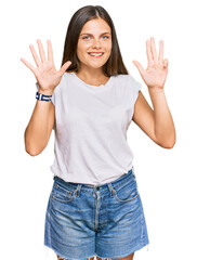 Young caucasian woman wearing casual white tshirt showing and pointing up with fingers number nine while smiling confident and happy.