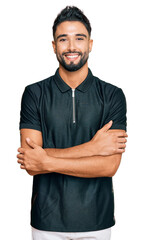 Young man with beard wearing sportswear happy face smiling with crossed arms looking at the camera. positive person.