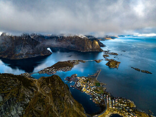 epic aerial view from Reinebringen mountain over norwegian lofoten islands fisherman village reine with clouds - obrazy, fototapety, plakaty