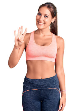 Young beautiful hispanic woman wearing sportswear showing and pointing up with fingers number four while smiling confident and happy.