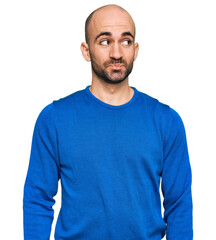 Fototapeta premium Young hispanic man wearing casual clothes smiling looking to the side and staring away thinking.