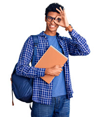 Young african american man wearing student backpack holding book doing ok gesture with hand smiling, eye looking through fingers with happy face.