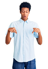 Young african american man wearing casual clothes pointing down with fingers showing advertisement, surprised face and open mouth