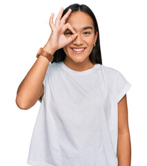 Young asian woman wearing casual white t shirt doing ok gesture with hand smiling, eye looking through fingers with happy face.