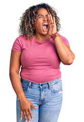 Young african american plus size woman wearing casual clothes shouting and screaming loud to side with hand on mouth. communication concept.