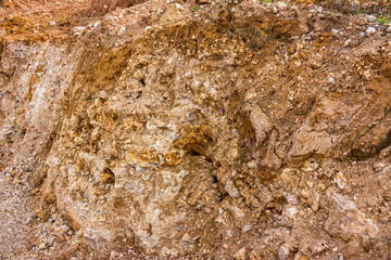 Surface of limestone quarry slope with stone and clay