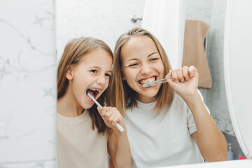 Mother and children brush their teeth in the bathroom. - Powered by Adobe