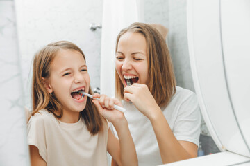 Mother and children brush their teeth in the bathroom.