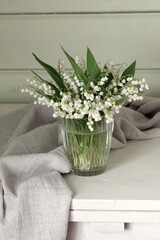 lilies of the valley in glass vase. cottage interior. summer stage creator.