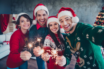 Photo of funky group buddies hold bengal fires make selfie record video christmas greetings apartment indoors