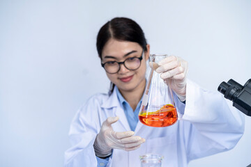 Laboratory researcher holding medical glass bottle with liquid, Scientist woman at job. Chemistry concept