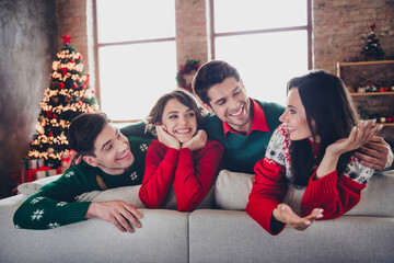 Photo of positive funky people sitting cozy sofa cuddle communicate christmas time miracle flat...