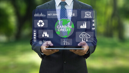 Carbon credit market concept. Reduction of carbon emissions, carbon neutral concept. Businessman uses technology to exchange carbon credits on virtual screen with net zero emissions, - obrazy, fototapety, plakaty