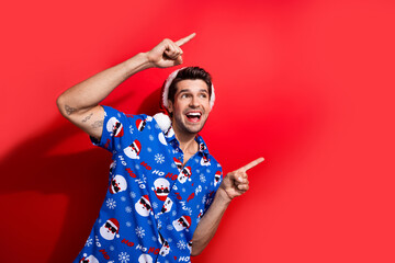 Photo portrait of handsome young guy point look empty space dressed santa claus print x-mas outfit...