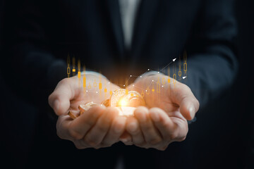 investment and finance concept, businessman holding virtual trading graph and blurred light on...