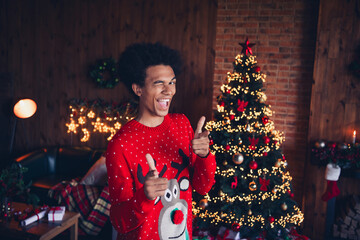Photo of funny cool guy dressed red ugly x-mas pullover winking pointing fingers you new year...