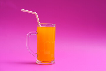 Glass mug of orange juice with drinking straw.  Pink background. Concept, morning refreshing beverage. Sweet, testy and high vitamin C.       - obrazy, fototapety, plakaty