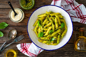 Penne with basil pesto sauce on wooden table
