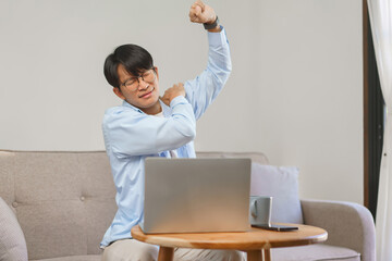 Home office, Businessman raising arm while exhausted and shoulders pain from office syndrome - obrazy, fototapety, plakaty