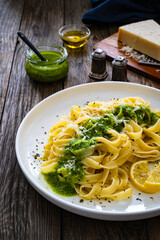 Tagliatelle with basil pesto sauce on wooden table