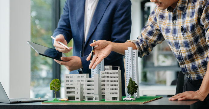 balancing the property sector The real estate agent is explaining the house style to see the house design and the purchase agreement. house city