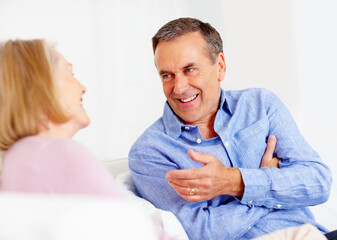 Obraz premium Home, relax and senior couple with love, conversation and communication with weekend break, cheerful and joy. Retirement, old man and mature woman with discussion, bonding together or talk with chat