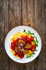 Linguine meatballs in bolognese sauce on wooden table