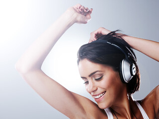 Music, dance and happy woman with headphones in studio with freedom, party and celebration. Dancer,...