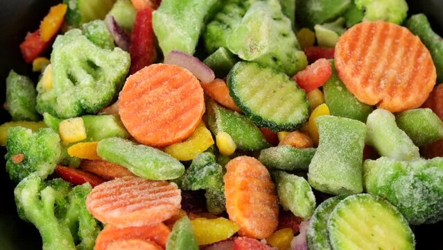 Zoom frame assorted frozen vegetables in plate, rotation. Healthy food, vegetarian cuisine