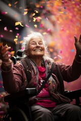 Elderly grandmother sits on wheelchair and enjoys flying confetti, happiness, joy, street festival,...