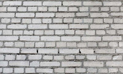 Old grey brick wall background. Rough brick wall texture. Abstract grey brick wall surface. Close up.