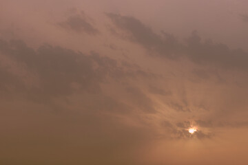 A sky, with diffused sun, clouds, colourful,