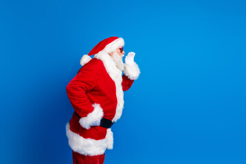 Photo portrait of pensioner senior man cover mouth share secret wear trendy santa claus costume coat isolated on blue color background