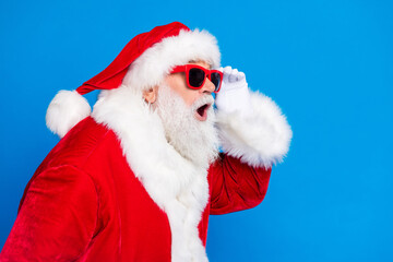 Photo portrait of mature pensioner man astonished reaction wear trendy santa claus costume coat isolated on blue color background