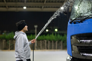 トラックを洗車する男性