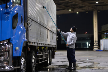 トラックを洗車する男性