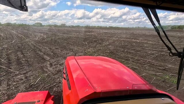 View from the cab of an agricultural tractor on the field.