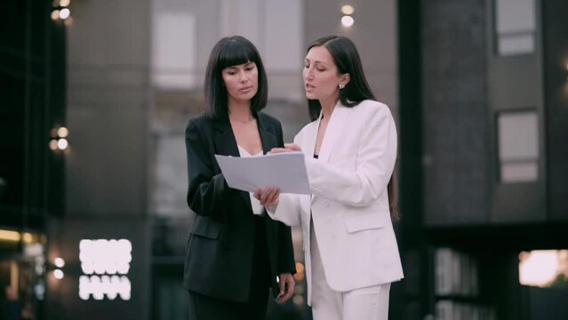 The boss scolds his subordinate. An angry female boss argues with a subordinate employee about documents. Two business women are arguing on the street.