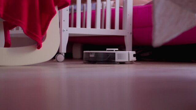 Robot vacuum cleaner that is sitting on the floor next to a chair. Smart Home
