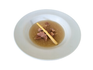 Indonesian beef soup or soto daging in a serving bowl, flat lay on white plate, isolated on white background