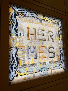 Brand Hermes boutique. Name of famous luxury French craftsmaker close-up. Art idea, bright creative label on the wall of official store, office. Hermès International, Hermès of Paris or Hermes. Famous
