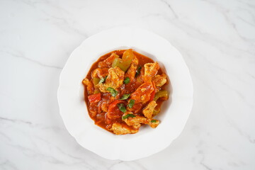 Chicken breast stew with vegetables and herbs and tomato sauce.