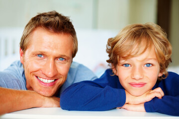 Happy, portrait and father with boy on bed for bonding, relaxing and spending time together. Smile, love and young dad chilling and resting with kid or child from Australia in bedroom of house.