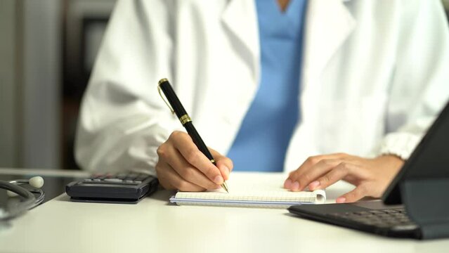 Doctor physician with stethoscope calculate medical fee costs & revenue. practitioner use calculator at Clinic.