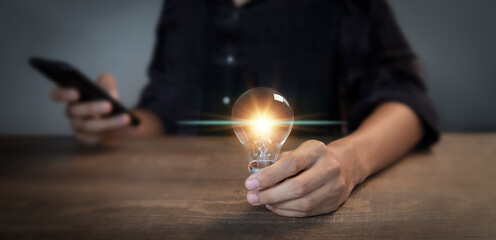 businessman holding an innovative light bulb creating new ideas inspirational ideas and problem solving