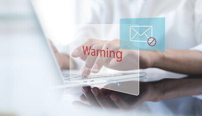 Blocking spam e-mail, warning pop-up for phishing mail, network security concept. Business woman working on laptop computer at home with warning window on screen, cyber security - obrazy, fototapety, plakaty