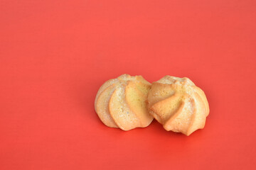 Two shortbread cookies, shaped like stars, lie on a red background.