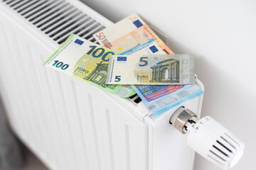  banknote lying on the radiator, the concept of rising energy prices and more expensive heating