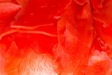 Top view of red pickled slices of ginger close-up